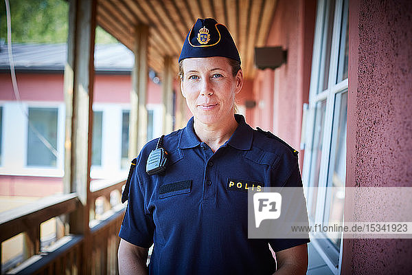Porträt einer Polizistin  die auf dem Balkon einer Polizeistation steht