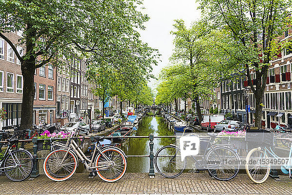 Bicycles on a bridge Bloemgracht Canal Amsterdam North Holland The Netherlands Europe