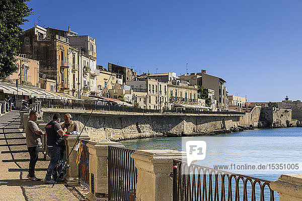 Fishermen deep in discussion waterfront Ortigia (Ortygia) Syracuse (Siracusa) UNESCO World Heritage Site Sicily Italy Mediterranean Europe