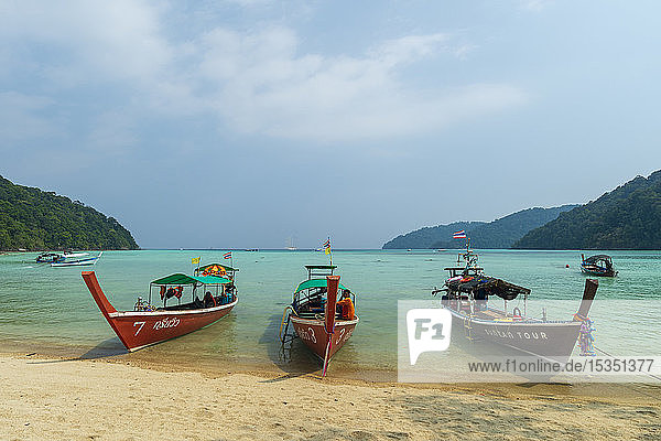 Three long tailed boats on a sandy beach  Thailand  Southeast Asia  Asia