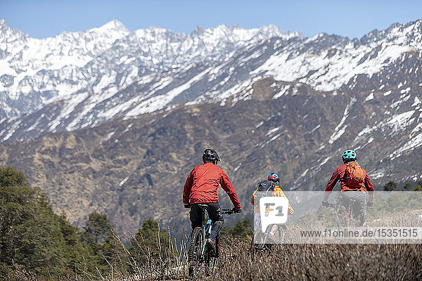 Mountainbiking im Himalaya mit Blick auf die Langtang-Bergkette in der Ferne  Nepal  Asien