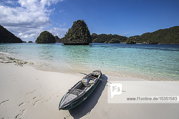 Karst limestone formations and lagoon in Wayag Island with the photographer's kayak  Raja Ampat  West Papua  Indonesia  Southeast Asia  Asia
