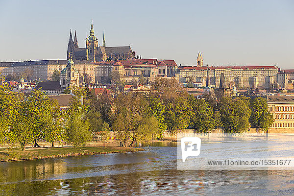 Die Prager Burg und der Veitsdom vom Ufer der Moldau aus gesehen im ersten Sonnenlicht  UNESCO-Weltkulturerbe  Prag  Böhmen  Tschechische Republik