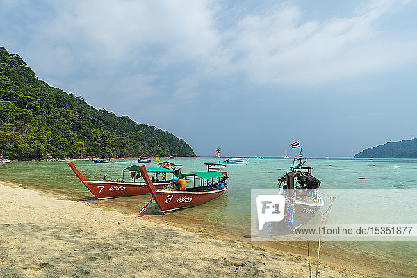 Three long tailed boats on a sandy beach  Thailand  Southeast Asia  Asia