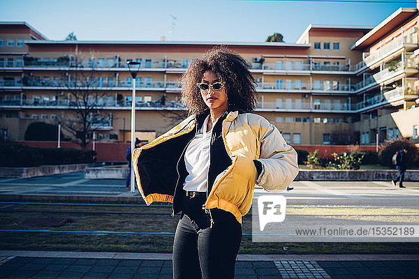 Coole junge Frau mit Sonnenbrille auf städtischem Bürgersteig  Porträt