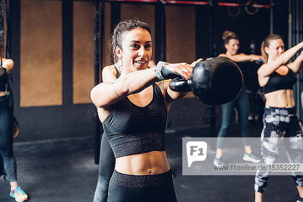 Women training in gym  lifting kettle bells