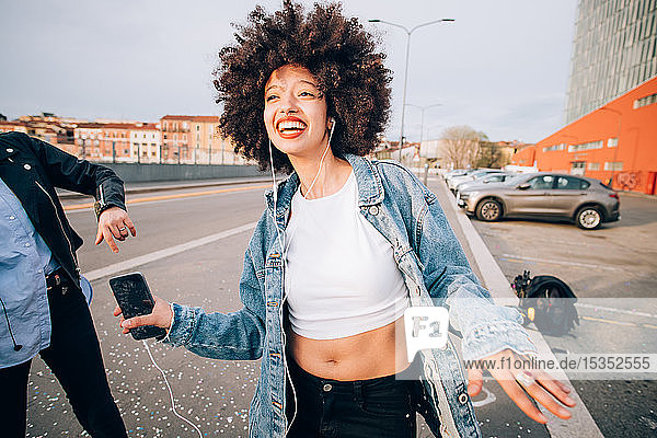 Freunde tanzen auf der Straße zu Smartphone-Musik  Mailand  Italien