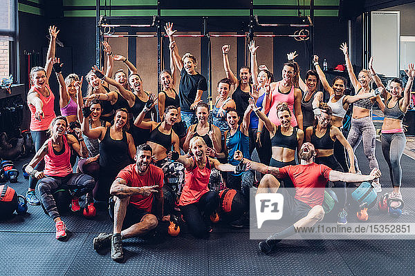 Large group of women training in gym with male trainers  posing for portrait