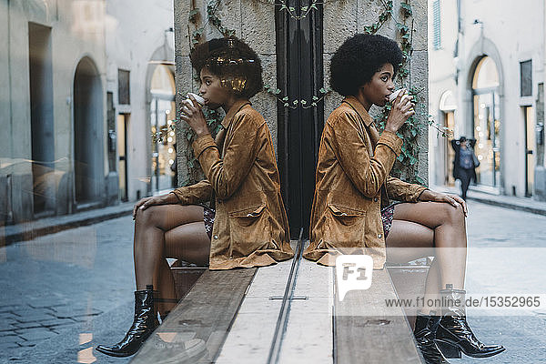 Junge Frau mit Afrohaaren bei einem Heißgetränk vor einem Cafe  Florenz  Toskana  Italien