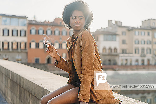 Junge Frau mit Afrohaaren raucht auf der Brücke  Florenz  Toskana  Italien