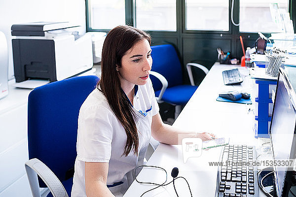Am Computer arbeitende Krankenschwester am Krankenhausempfang