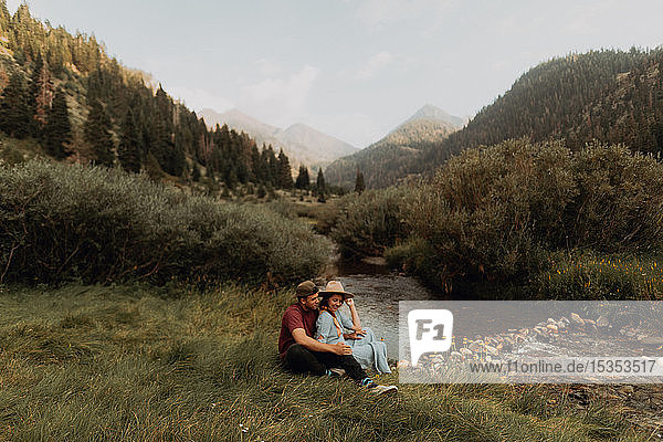 Junges Paar sitzt am ländlichen Fluss  Mineral King  Kalifornien  USA