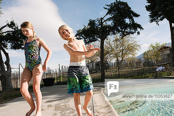 Brother and sister playing by swimming pool  Olancha  California  US