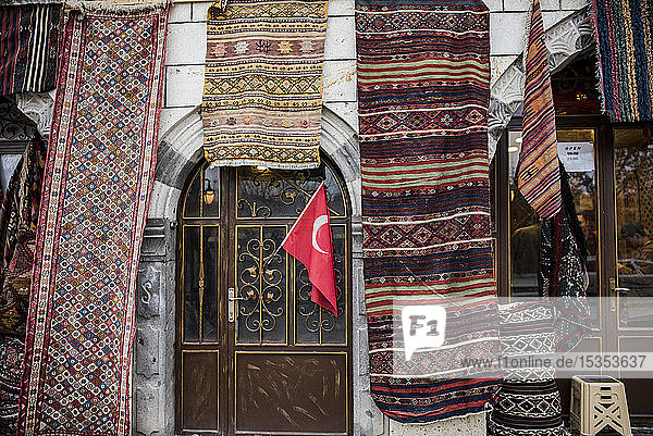 Ausstellung einer Vielzahl von Teppichen und Läufern an der Fassade eines Geschäfts  Goreme  Kappadokien  Türkei