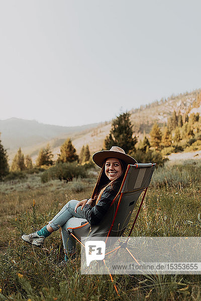 Young woman looking back from deck chair in rural valley  portrait  Mineral King  California  USA