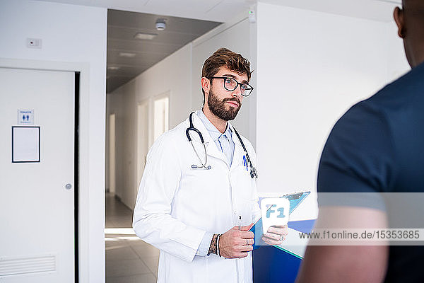 Arzt spricht mit Patient am Krankenhausempfang