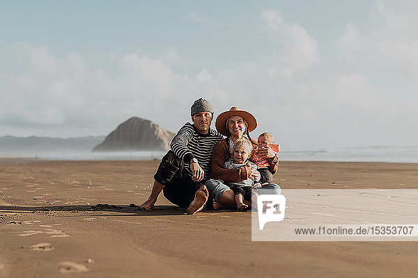 Parents and children sitting on beach  Morro Bay  California  United States