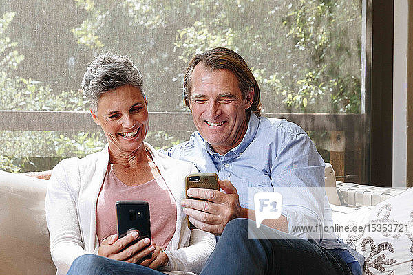 Couple laughing at cellphone messages