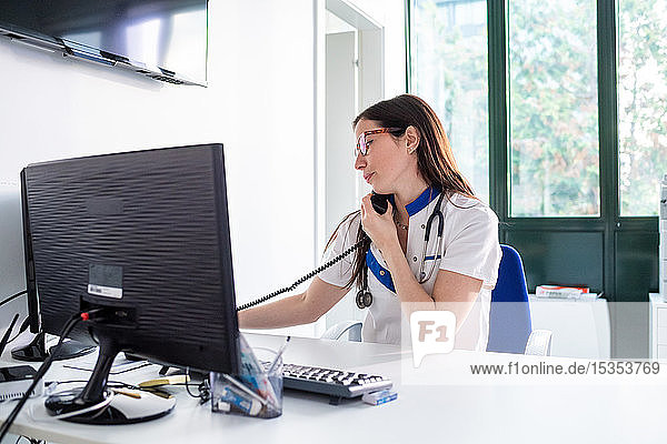 Nurse talking on telephone in hospital