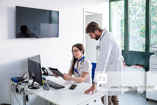 Arzt und Krankenschwester verwenden digitales Tablett im Krankenhaus