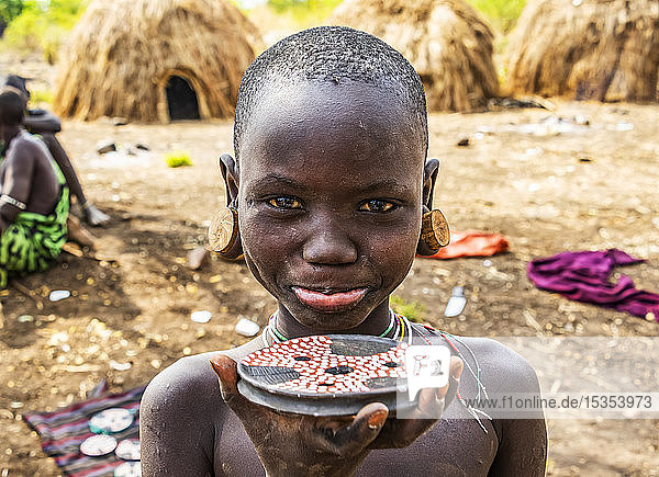 Mursi-Junge zeigt ein Lippenschild in einem Dorf im Mago-Nationalpark; Omo-Tal  Äthiopien