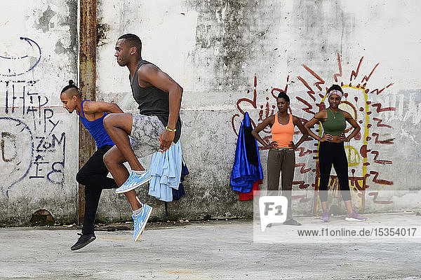 Junge kubanische Männer tanzen in einem alten Betongebäude mit Graffiti an den Wänden; Havanna  Kuba