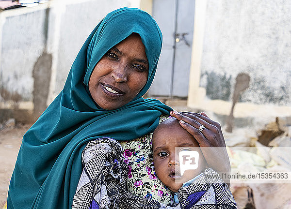 Äthiopische Frau hält einen Jungen in Harar Jugol  der befestigten historischen Stadt; Harar  Region Harari  Äthiopien