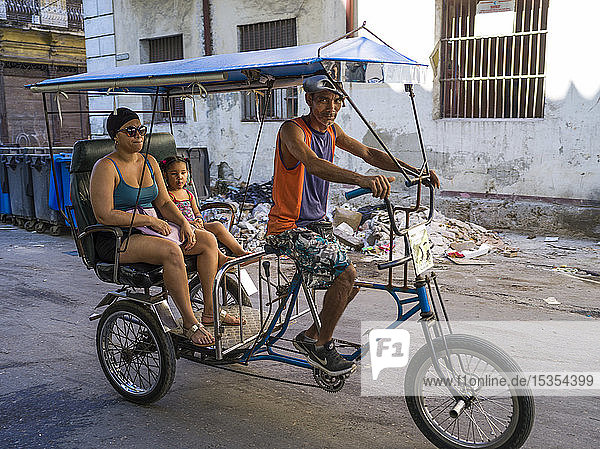 Pedicab mit einem anderen und einer Tochter in den Straßen von Havanna; Havanna  Kuba