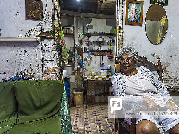 Ältere kubanische Frau sitzt auf einem Stuhl in ihrem Haus; Havanna  Kuba