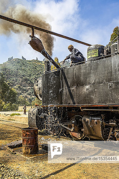 Ingenieur füllt Wasser in die Dampflokomotive Ansaldo 442 aus dem Jahr 1938  die für den Transport von Gütern von der Hafenstadt Massawa zur Hauptstadt Asmara eingesetzt wird; Arbaroba  Zentralprovinz  Eritrea