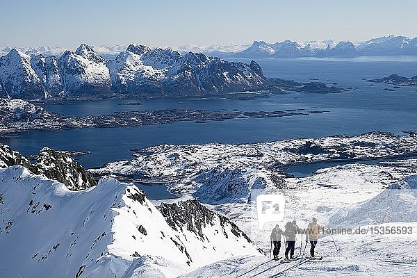 Skitourengeher beim Aufstieg zum Rundfjellet hinten das Nordmeer Svolvaer Austvågøy Lofoten Norwegen Europa