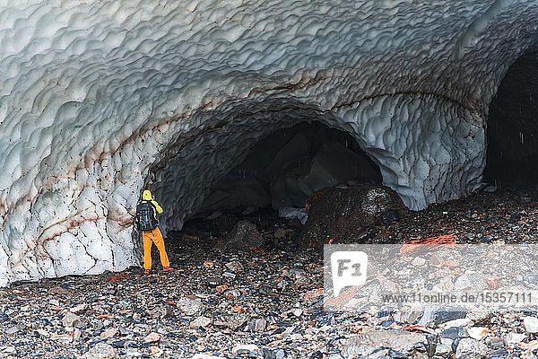 Man at the entrance of an ice cave of a glacier  Big Four Ice Caves  Okanogan-Wenatchee National Forest  Washington  USA  North America