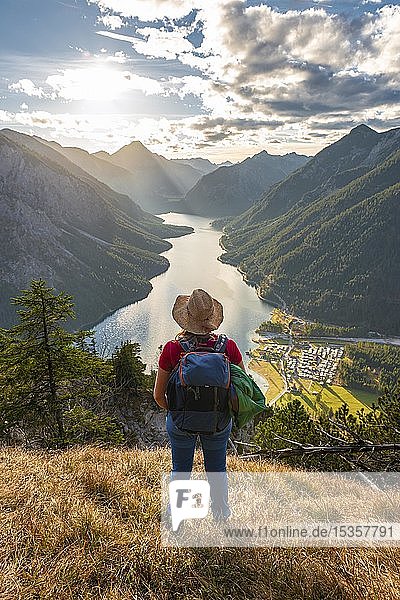 Female hiker with a sun hat looking into the distance  Lake Plansee  Ammergauer Alps  Reutte district  Tyrol  Austria  Europe