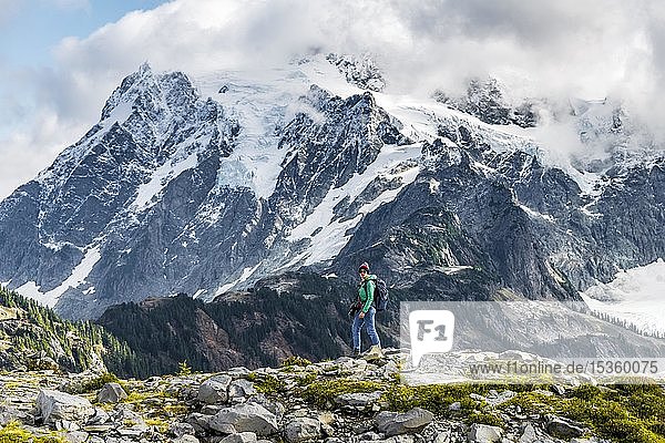 Female hiker with view of Mt. Shuksan with snow and glacier  cloudy sky  Mt. Baker-Snoqualmie National Forest  Washington  USA  North America