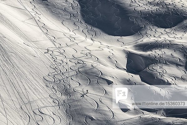 Skispuren und Tourengeher  die zwischen Skispuren auf tief verschneiten Hängen aufsteigen  Gramais  Lechtal  Tirol  Österreich  Europa