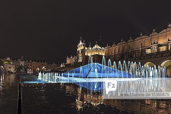 Beleuchteter Springbrunnen mit Tuchhallen bei Nacht  Marktplatz  Krakau  Polen  Europa