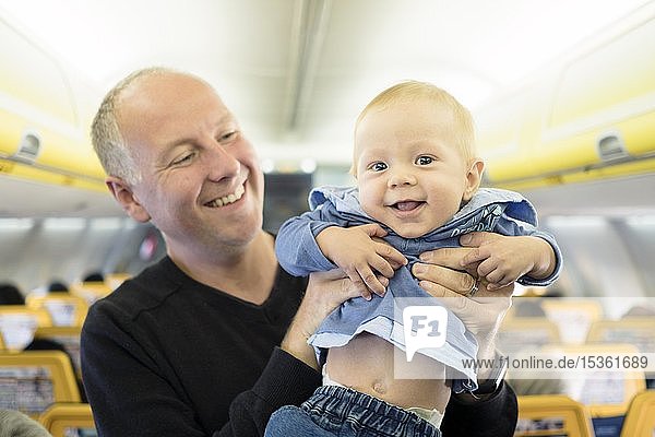 Father standing with his six months old baby boy in the airplane  Spain  Europe