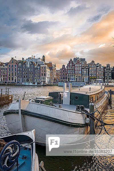 Blick über die Amstel im Abendlicht  Gracht mit Boot und historischen Häusern  Amsterdam  Nordholland  Niederlande