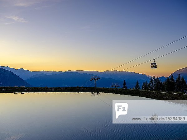 Alpenpanorama Gondel der Seilbahn Jennerbahn spiegelt sich im Abendlicht in einem künstlichen Bergsee Jenner Berchtesgadener Alpen Schönau am Königssee Berchtesgadener Land Oberbayern Bayern Deutschland Europa