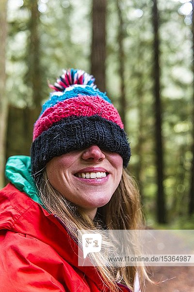 Portrait  laughing woman with poodle cap over her eyes in the forest  Mount Baker-Snoqualmie National Forest  Washington  USA  North America