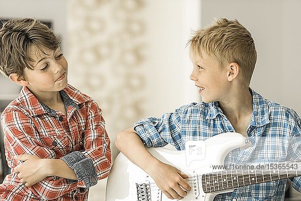 Zwei Jungen  Freunde  10 Jahre alt  einer spielt E-Gitarre  lächelnd  Deutschland  Europa