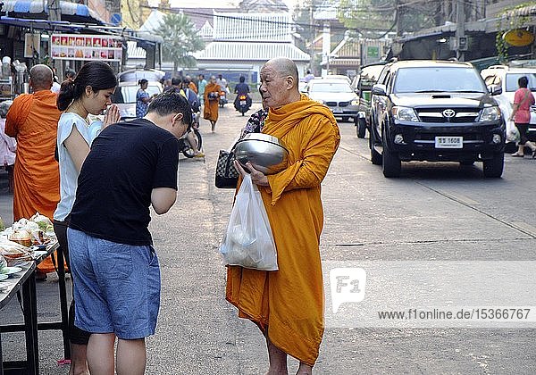 Faithful Thais bow in front of a begging monk  Bangkok  Thailand  Asia