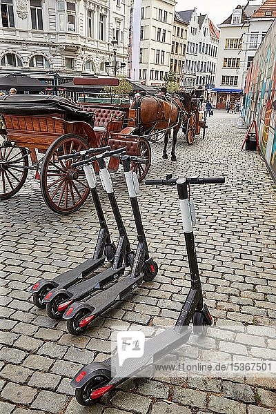 Elektroroller zum Mieten neben einer Pferdekutsche auf dem Grote Markt in Antwerpen Belgien Europa