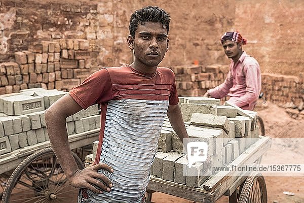 Arbeiter einer Ziegelei  stehend vor Karren mit Ziegeln  Dhaka  Bangladesch  Asien