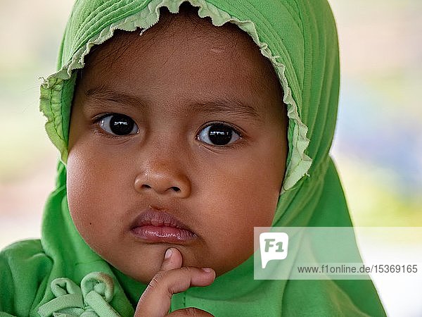 Kleines indonesisches Mädchen mit Kopftuch schaut nachdenklich  Porträt  Java  Indonesien  Asien