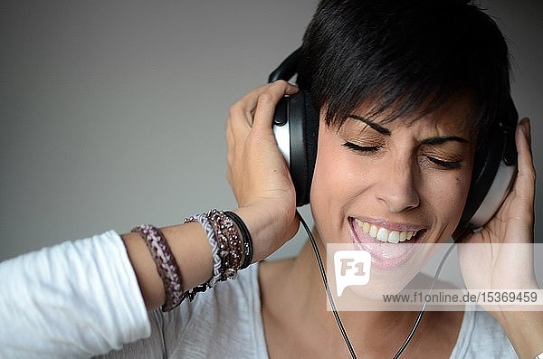 Young woman listening to music with headphones  portrait  Spain  Europe
