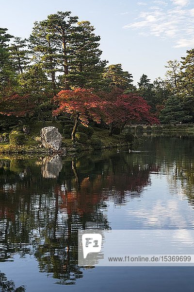 Bäume mit rotem Herbstlaub am Wasser Kenroku-en Garten Kanazawa Japan Asien