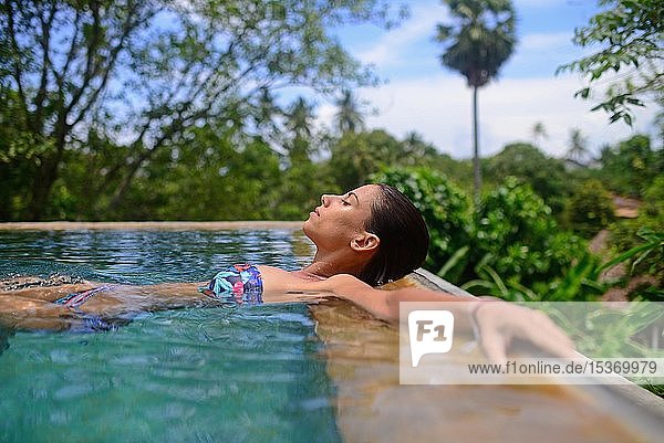 Junge Frau genießt ein Bad in einem Swimmingpool  Galle  Sri Lanka  Asien