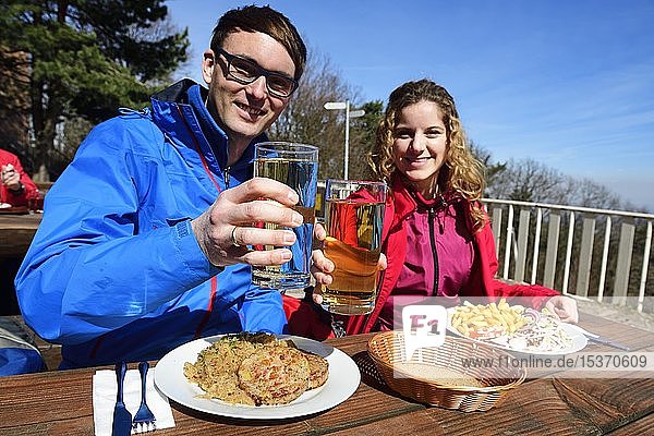 Hikers enjoying a hearty snack with Palatinate Saumagen and sausage salad in front of the Kalmithaus on the summit of Kalmit  German Wine Route  Rhineland-Palatinate  Germany  Europe