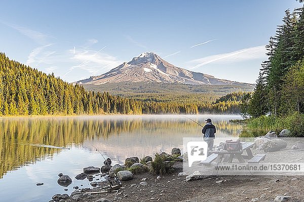 Angler at the lake  Trillium Lake  back volcano Mt. Hood  morning mood  Oregon  USA  North America